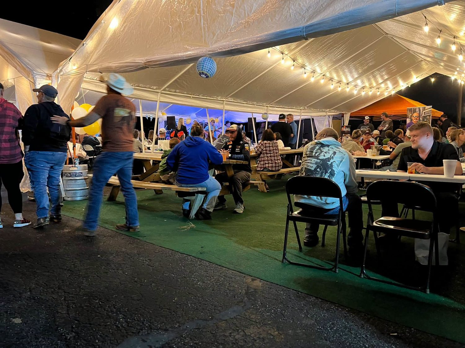 A live band and a full crowd under the tents at night